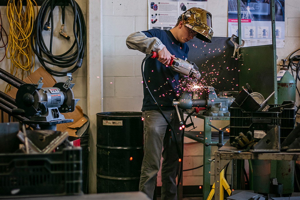 Student using metalworking tool in a shop