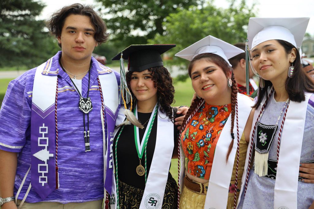 Four students gather at the graduation ceremony