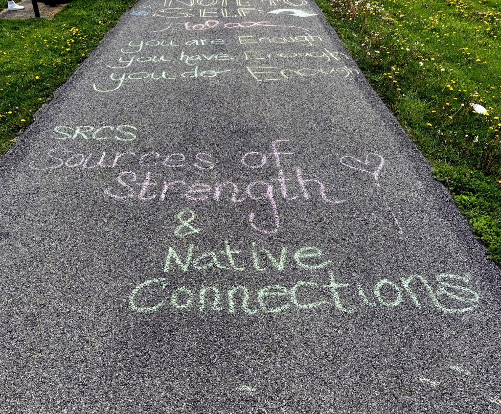 Chalk on pavement says "SRCS Sources of strength and native connections