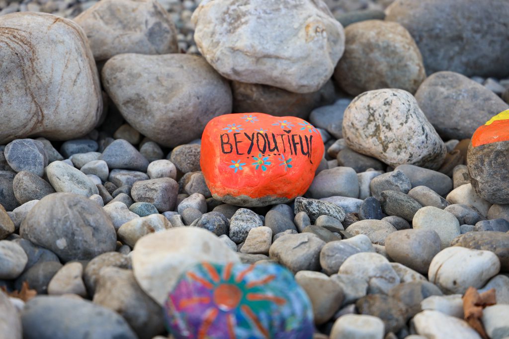 A closeup shot of a colorful rock that says 'Beyoutiful'