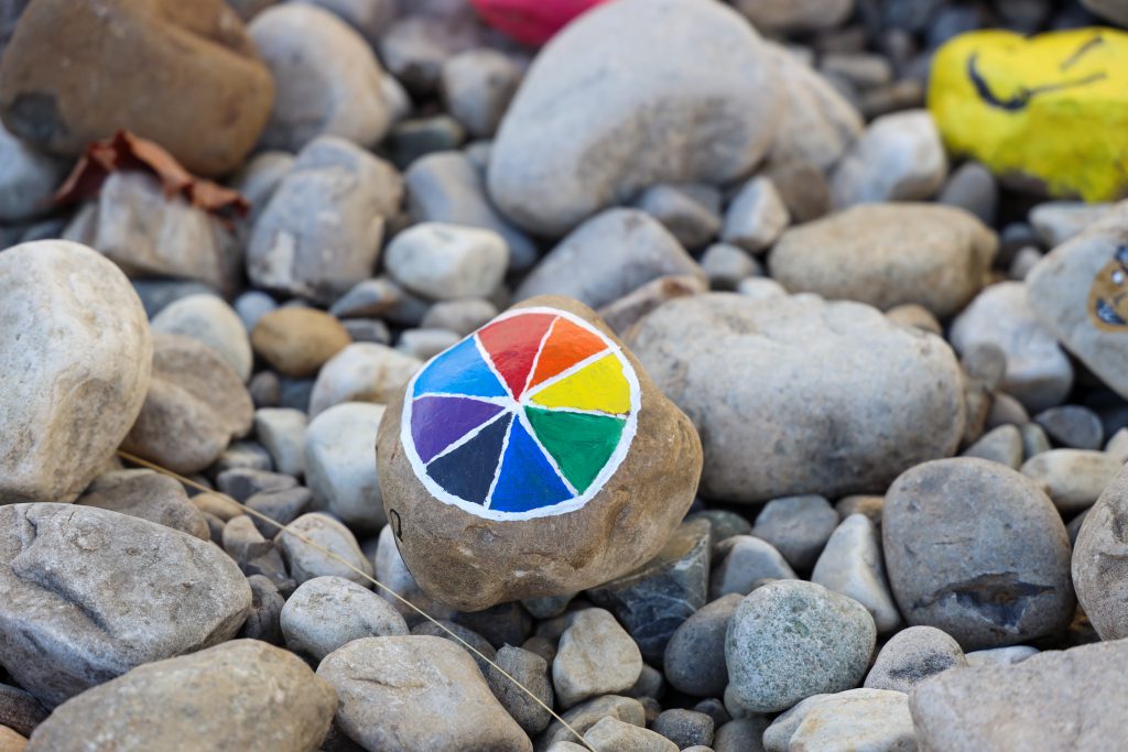 A closeup photo of a rock with a colorful pinwheel on it